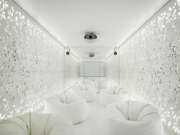Modelo de cine en casa cerrado minimalista grande con paredes blancas y pantalla de proyección