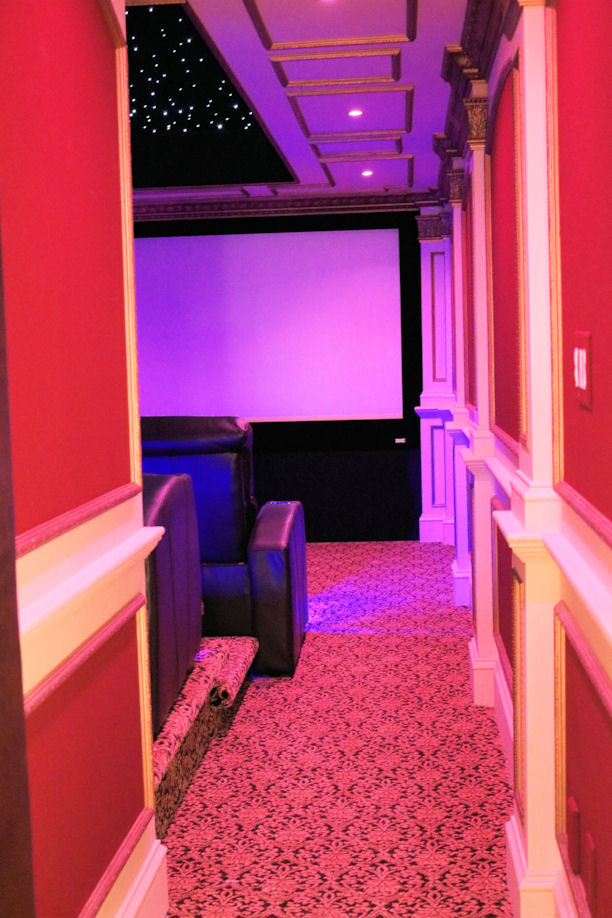 This is an example of a medium sized modern enclosed home cinema in Boston with carpet and a projector screen.