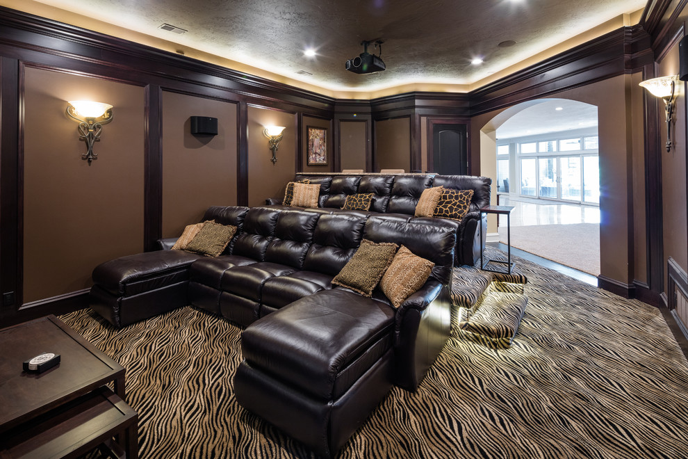 Large classic enclosed home cinema in Other with brown walls, carpet and a projector screen.