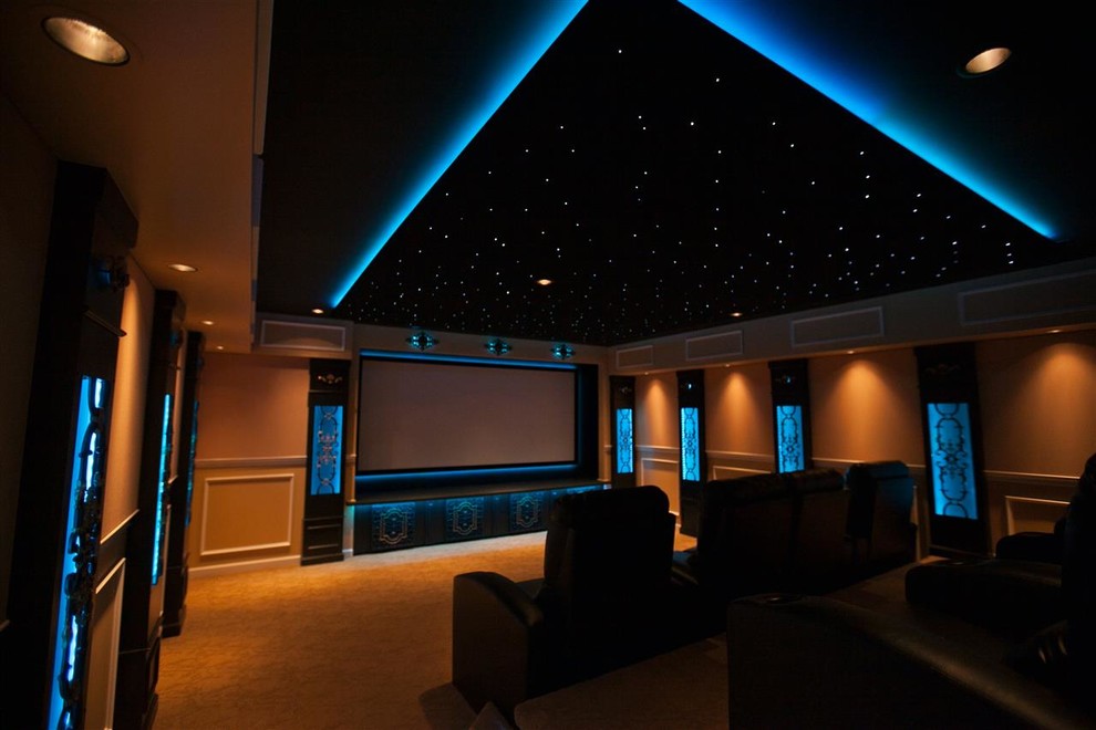 Стильный дизайн: большой изолированный домашний кинотеатр в классическом стиле с бежевыми стенами, ковровым покрытием, проектором и оранжевым полом - последний тренд