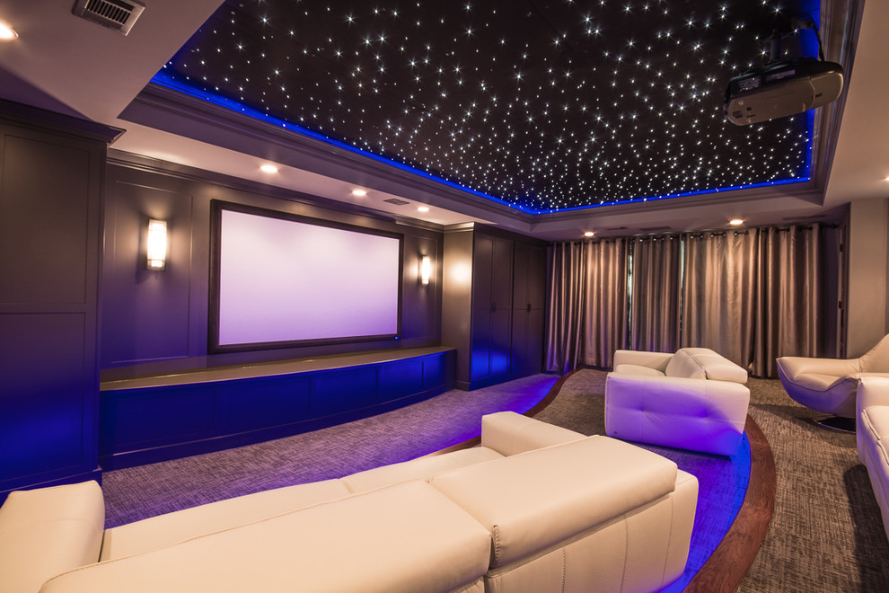 Aménagement d'une grande salle de cinéma contemporaine fermée avec un mur gris, moquette, un écran de projection et un sol gris.
