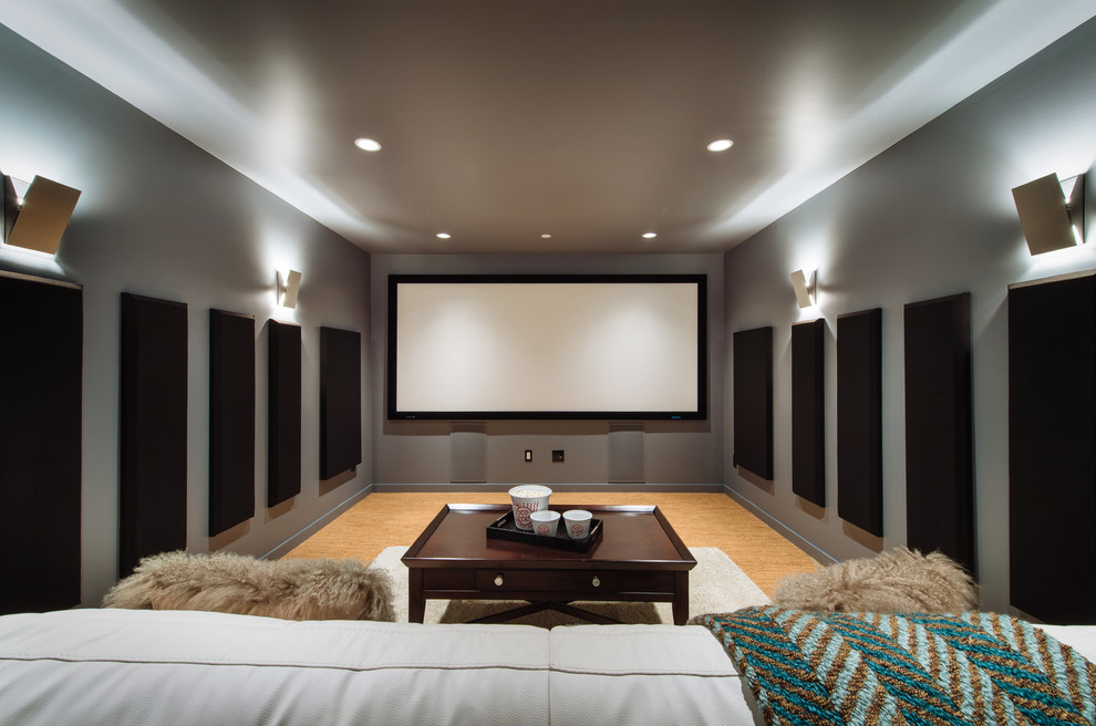 Imagen de cine en casa cerrado actual con paredes grises, suelo de corcho, televisor colgado en la pared y suelo naranja