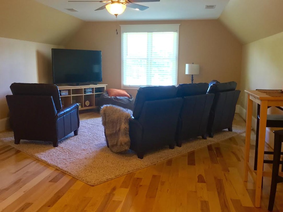 Medium sized classic home cinema in Charlotte with yellow walls, medium hardwood flooring and a wall mounted tv.