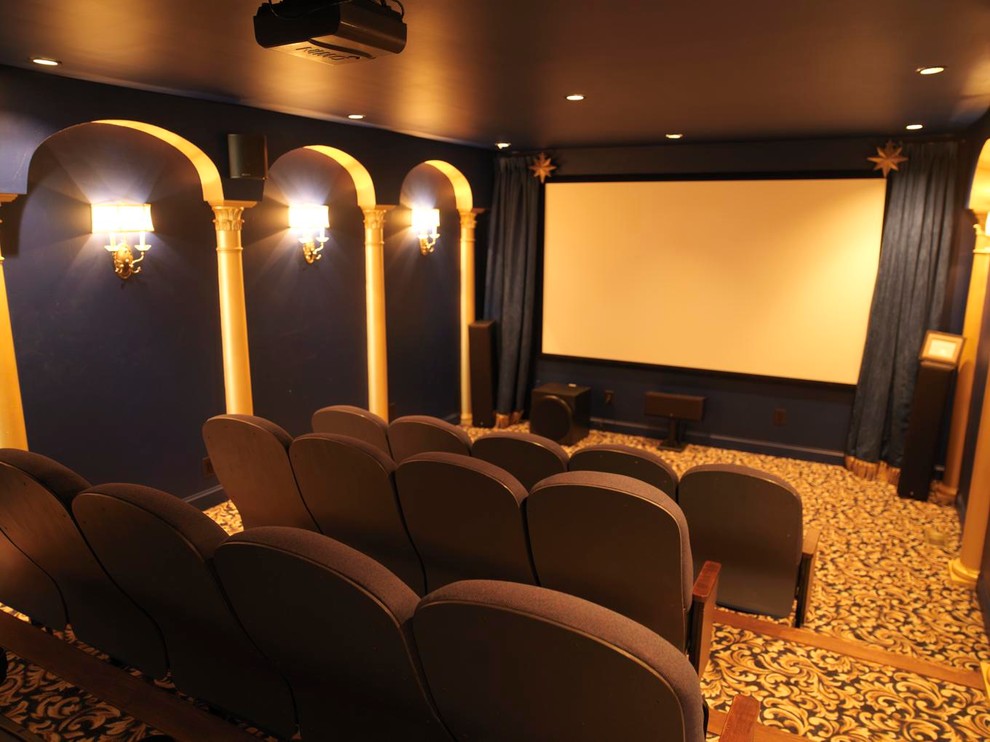 Modelo de cine en casa cerrado clásico de tamaño medio con paredes azules, moqueta y pantalla de proyección