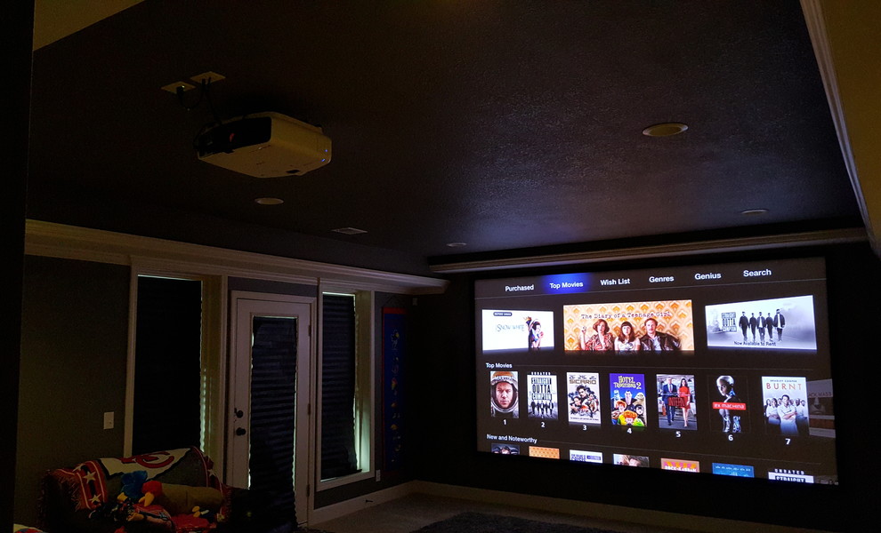 Inspiration for a large modern enclosed home cinema in Kansas City with a projector screen.