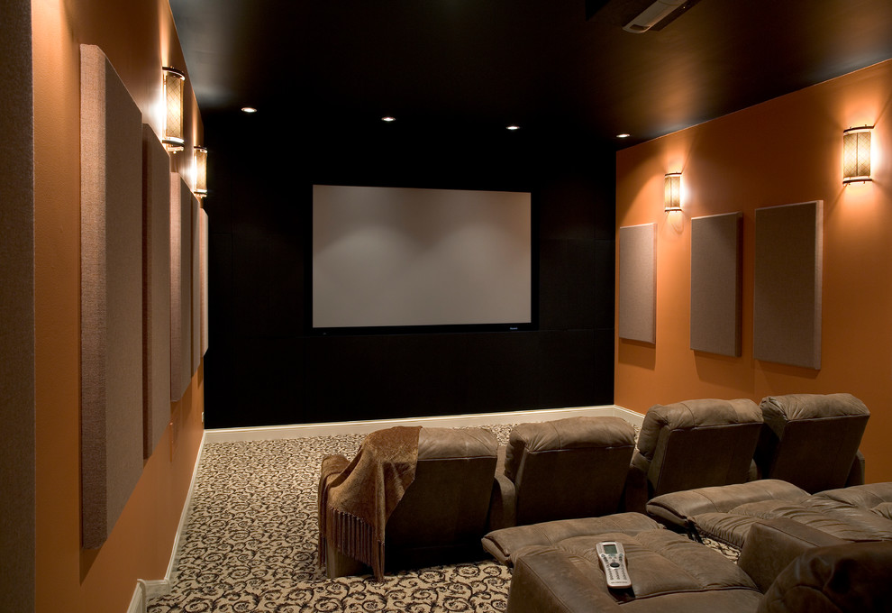 Идея дизайна: большой изолированный домашний кинотеатр в классическом стиле с оранжевыми стенами, ковровым покрытием, проектором и разноцветным полом