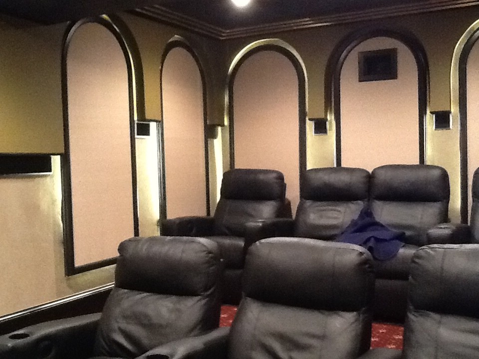 Example of a large enclosed home theater design in Chicago with a projector screen
