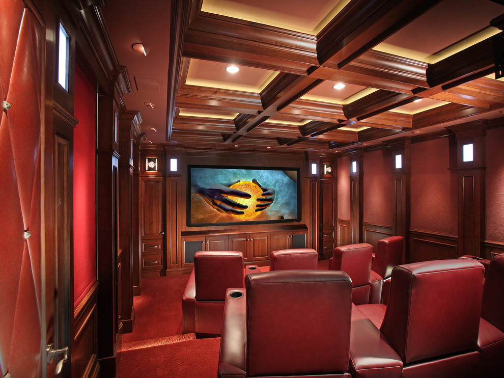 Diseño de cine en casa cerrado clásico con paredes rojas, moqueta, televisor colgado en la pared y suelo rojo