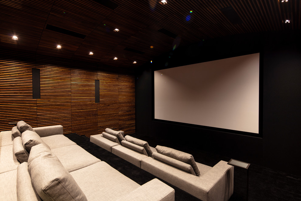 Ispirazione per un ampio home theatre moderno chiuso con pareti nere, schermo di proiezione e pavimento nero