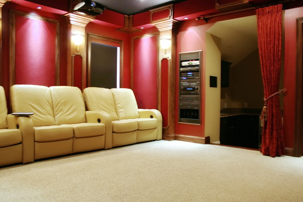Cette photo montre une salle de cinéma chic fermée avec un mur rouge, moquette, un écran de projection et un sol beige.