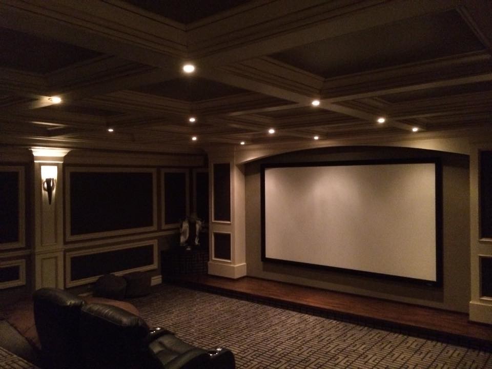 Large enclosed home cinema in Salt Lake City with brown walls, medium hardwood flooring and a projector screen.
