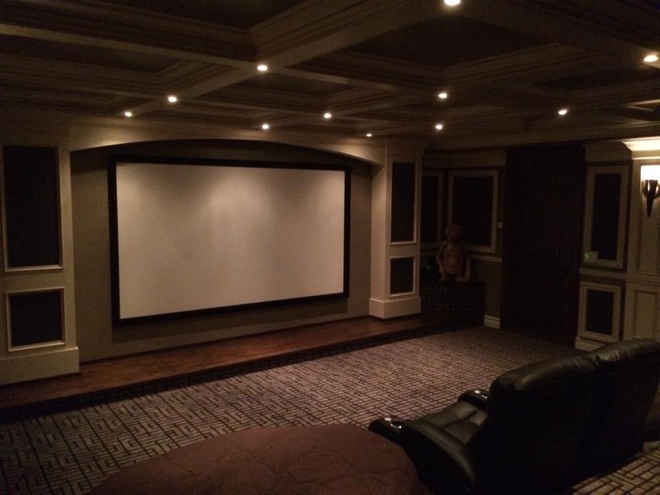 Immagine di un grande home theatre chiuso con pareti verdi, pavimento in legno massello medio e schermo di proiezione