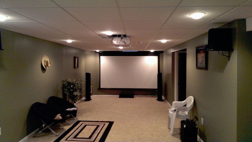 Cette photo montre une salle de cinéma chic de taille moyenne et fermée avec un mur vert, moquette et un écran de projection.