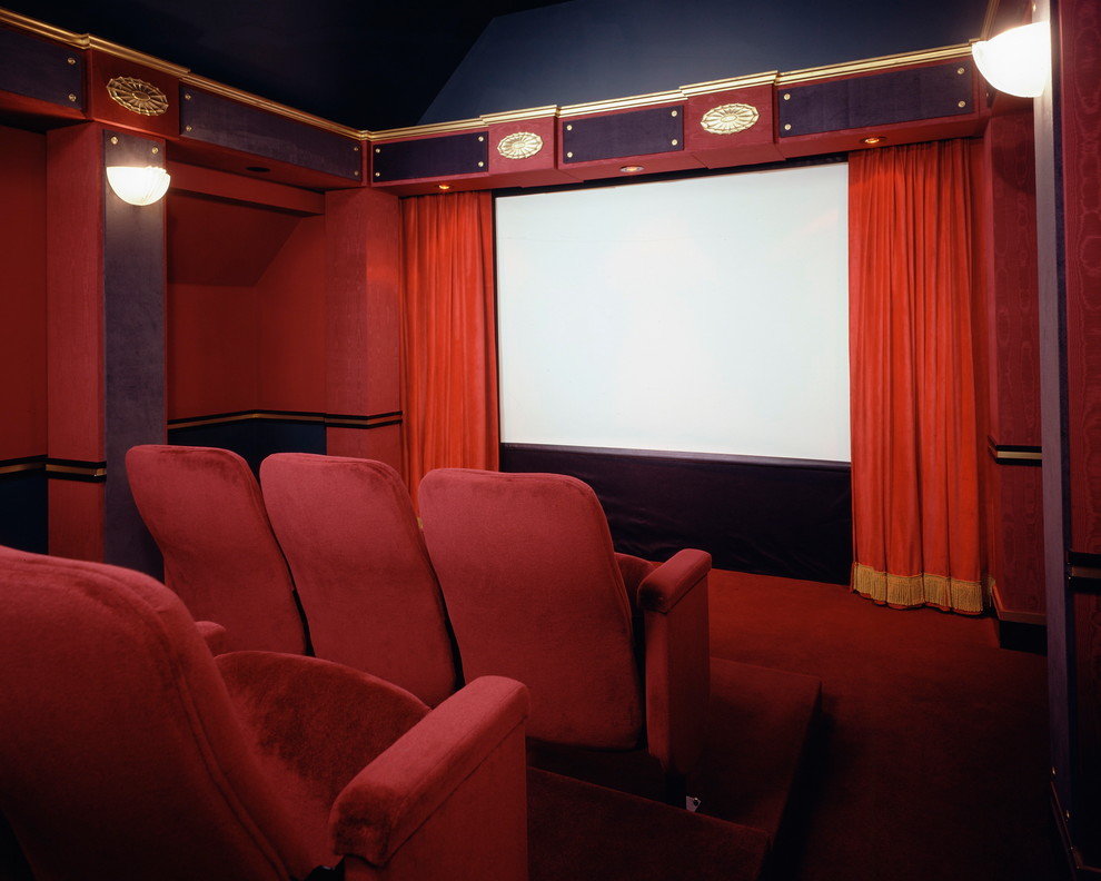Diseño de cine en casa cerrado clásico de tamaño medio con paredes rojas, moqueta y pantalla de proyección