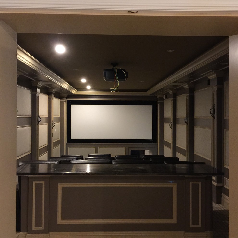 Imagen de cine en casa cerrado tradicional de tamaño medio con paredes beige, moqueta y pantalla de proyección