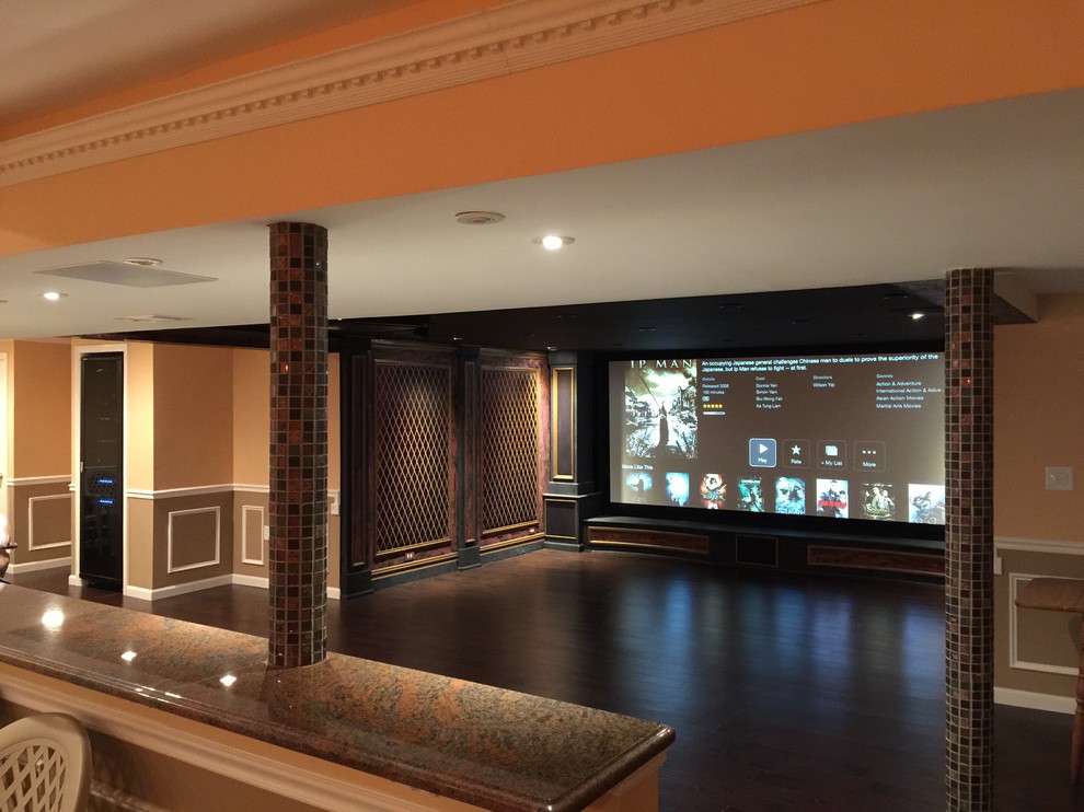 This is an example of a medium sized mediterranean open plan home cinema in New York with dark hardwood flooring, a projector screen and red walls.