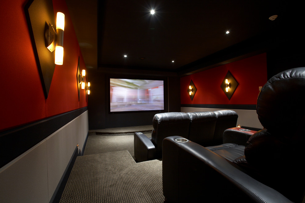 Imagen de cine en casa cerrado tradicional de tamaño medio con moqueta, pantalla de proyección y paredes rojas