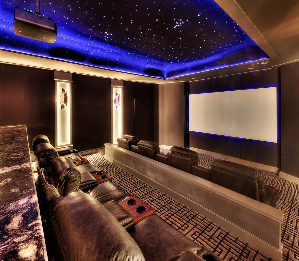 На фото: изолированный домашний кинотеатр в современном стиле с проектором, коричневыми стенами, ковровым покрытием и разноцветным полом