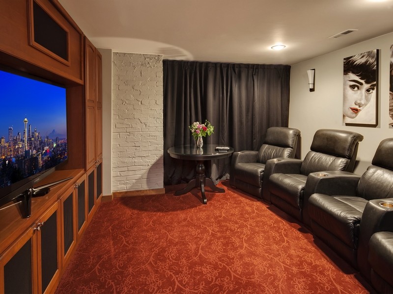 Photo of a classic enclosed home cinema in Seattle with white walls, carpet and a built-in media unit.