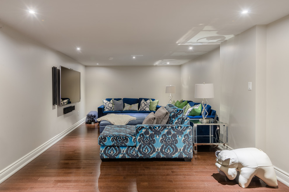 Medium sized classic open plan home cinema in Toronto with grey walls, medium hardwood flooring and a wall mounted tv.