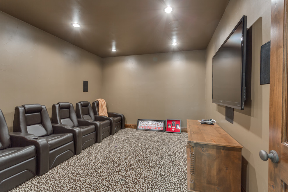Imagen de cine en casa cerrado clásico de tamaño medio con paredes marrones, moqueta, televisor colgado en la pared y suelo multicolor
