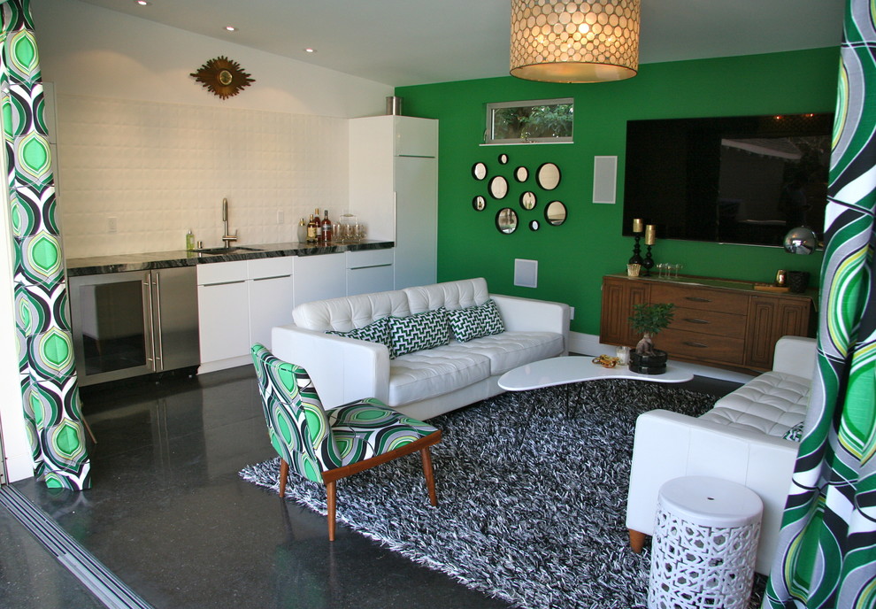 На фото: открытый домашний кинотеатр среднего размера в стиле ретро с зелеными стенами, бетонным полом и телевизором на стене с