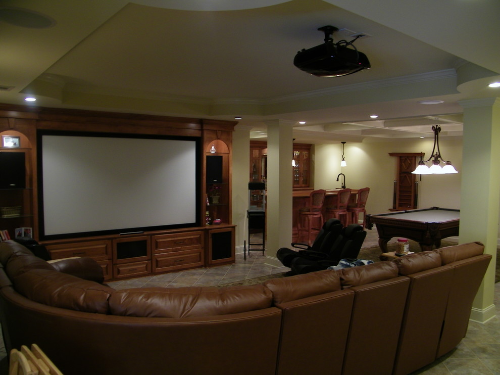 На фото: открытый домашний кинотеатр среднего размера в классическом стиле с бежевыми стенами, полом из травертина, проектором и коричневым полом с