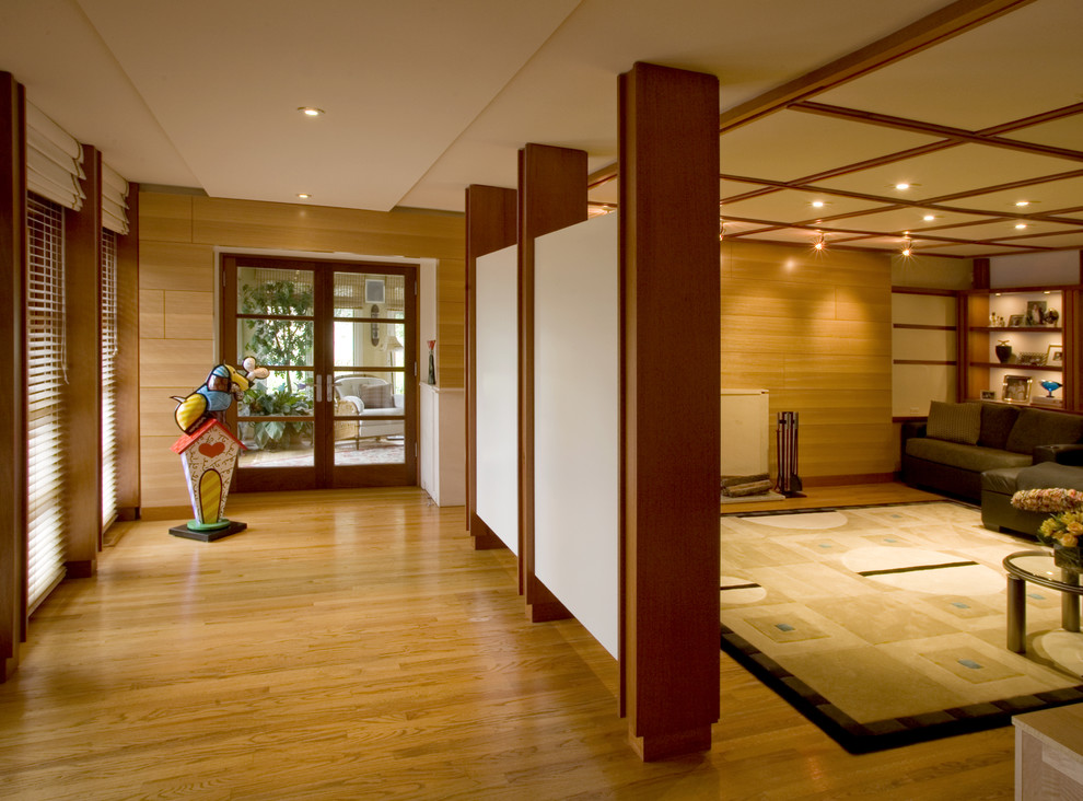 Imagen de cine en casa cerrado actual de tamaño medio con paredes multicolor, suelo de madera clara, pared multimedia y suelo beige