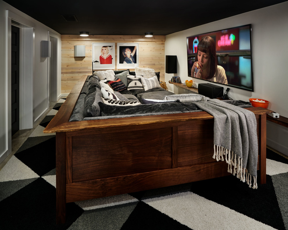 This is an example of a small bohemian enclosed home cinema in Portland with white walls, concrete flooring, a wall mounted tv and grey floors.