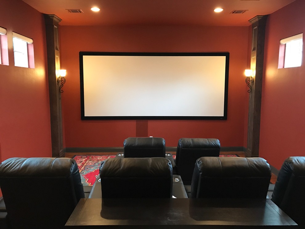 Home theater - mid-sized mediterranean enclosed medium tone wood floor home theater idea in Dallas with red walls and a projector screen