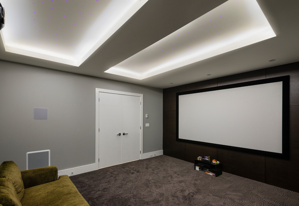 Ejemplo de cine en casa cerrado contemporáneo de tamaño medio con paredes grises, moqueta, pantalla de proyección y suelo gris