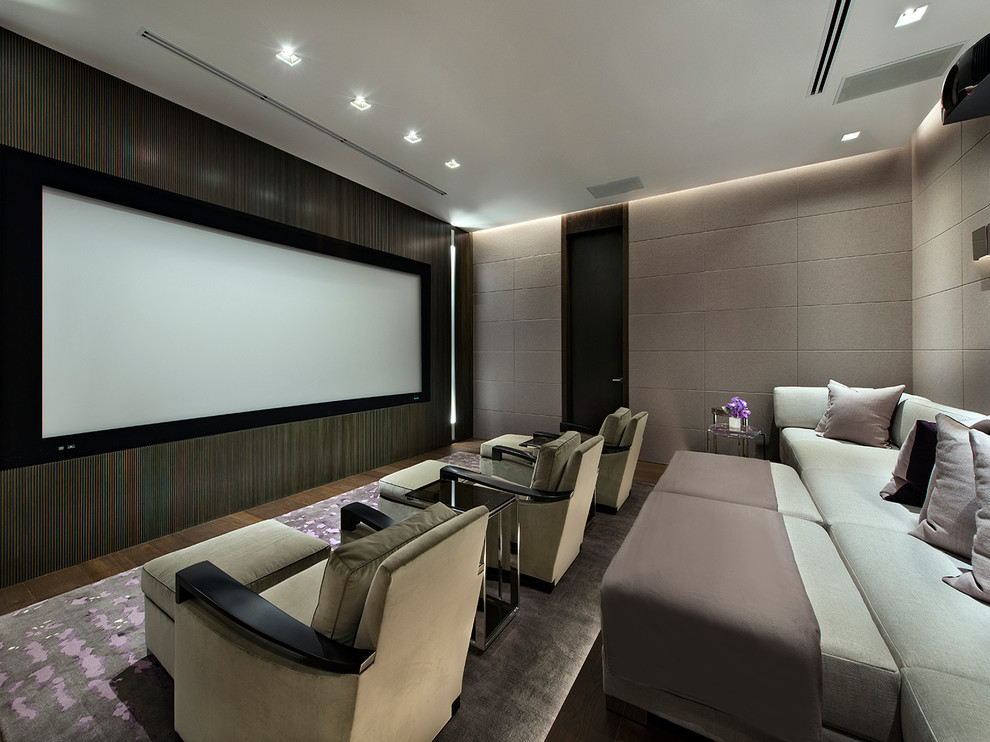 Idée de décoration pour une grande salle de cinéma design fermée avec un mur gris, parquet foncé et un écran de projection.