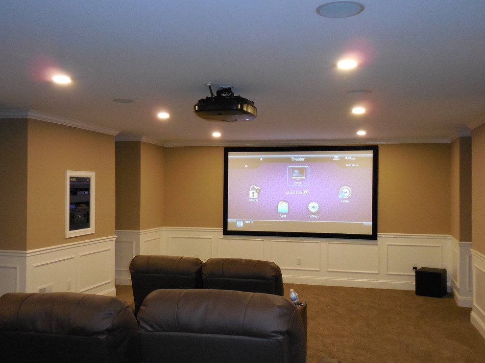 Cette image montre une grande salle de cinéma traditionnelle ouverte avec un mur beige, moquette et un écran de projection.