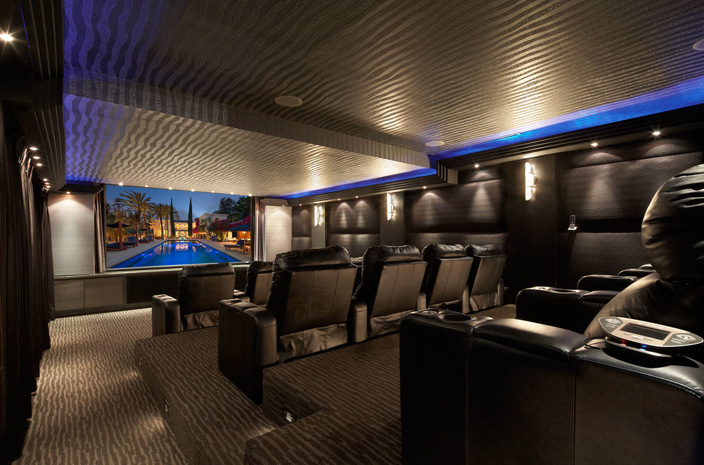 Contemporary enclosed home cinema in Los Angeles with black walls, carpet and a built-in media unit.