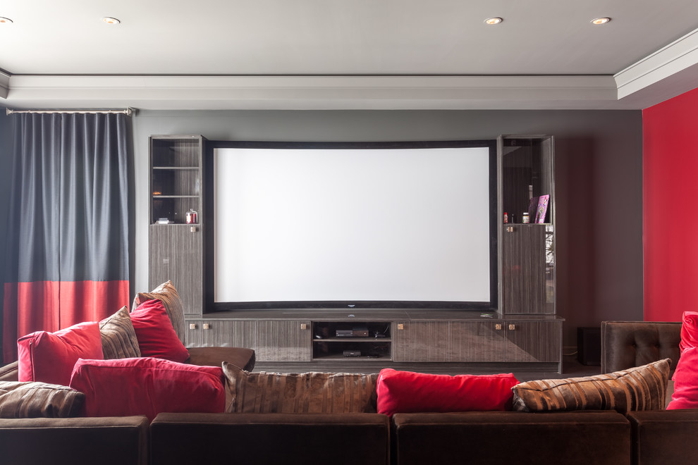 Ejemplo de cine en casa cerrado actual extra grande con paredes grises, suelo de baldosas de porcelana, pantalla de proyección y suelo marrón