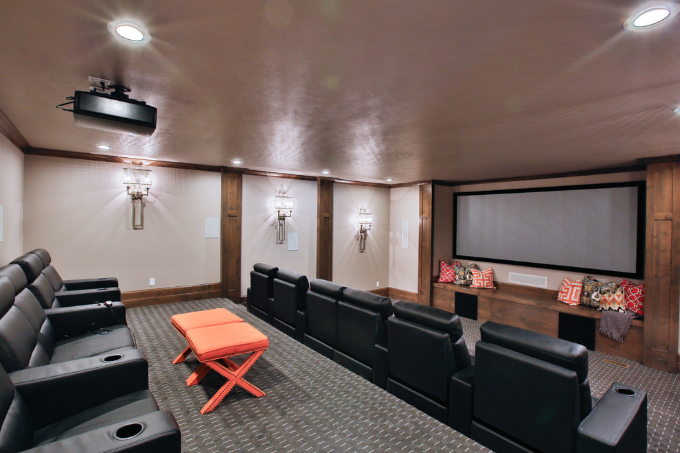 Cette image montre une grande salle de cinéma traditionnelle fermée avec un mur beige, moquette et un écran de projection.