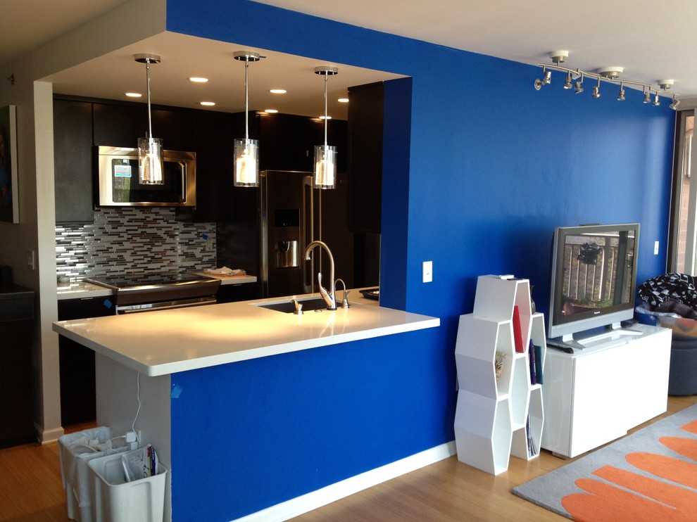Immagine di un piccolo home theatre design aperto con pareti blu, pavimento in bambù e TV a parete