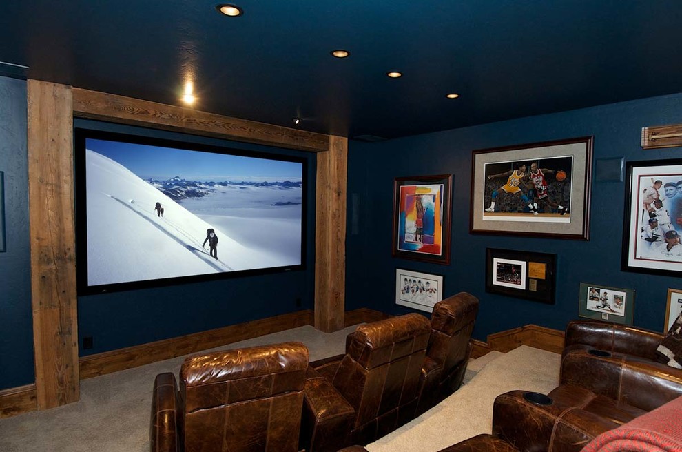 Стильный дизайн: большой изолированный домашний кинотеатр в стиле рустика с синими стенами, ковровым покрытием, проектором и бежевым полом - последний тренд