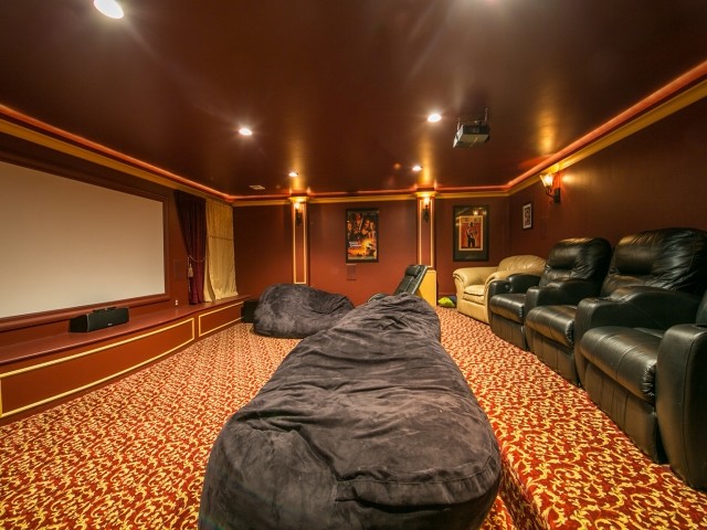 Идея дизайна: большой изолированный домашний кинотеатр в стиле кантри с красными стенами и ковровым покрытием
