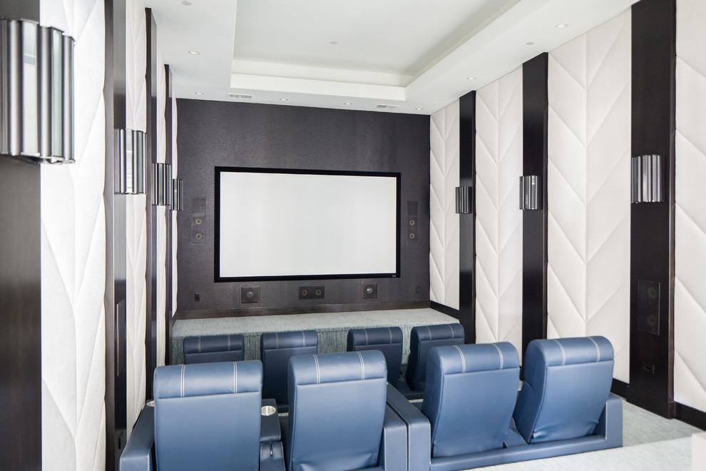 На фото: огромный изолированный домашний кинотеатр в средиземноморском стиле с ковровым покрытием, разноцветными стенами, проектором и серым полом с