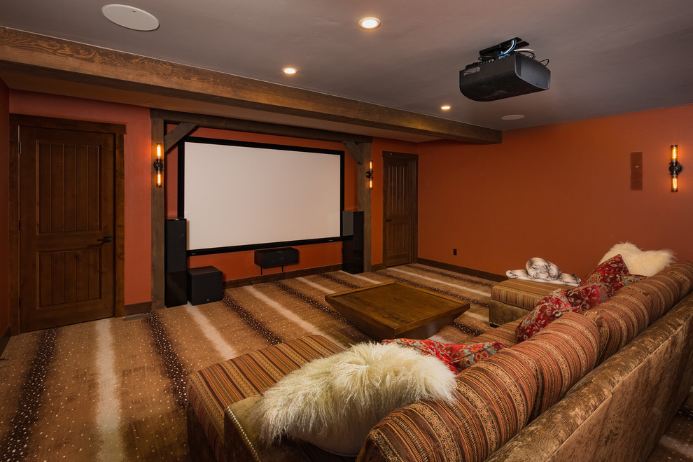 Идея дизайна: большой изолированный домашний кинотеатр в стиле рустика с красными стенами, ковровым покрытием, проектором и разноцветным полом
