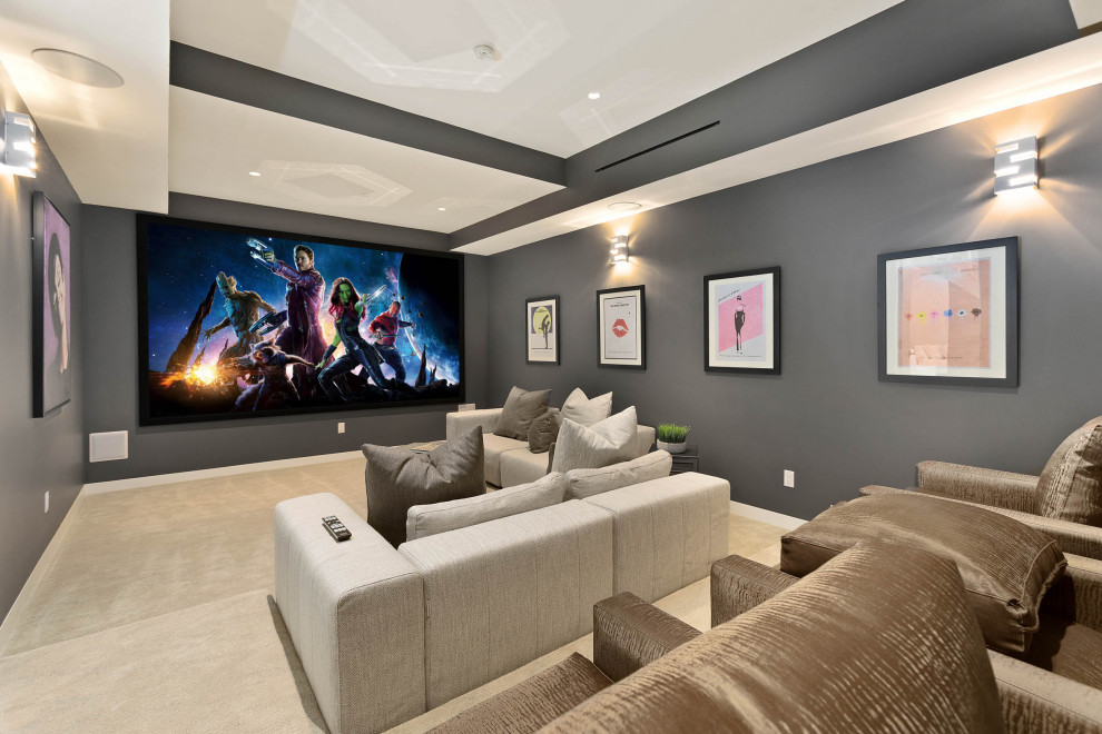 Imagen de cine en casa cerrado actual de tamaño medio con paredes grises, moqueta, pantalla de proyección y suelo beige