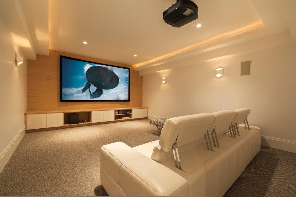 Modelo de cine en casa cerrado actual con paredes beige, moqueta, pantalla de proyección y suelo beige