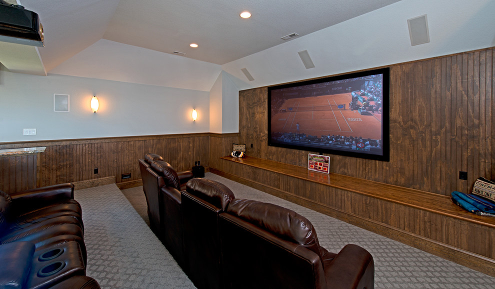 Large traditional enclosed home cinema in Other with grey walls, carpet, a projector screen and beige floors.