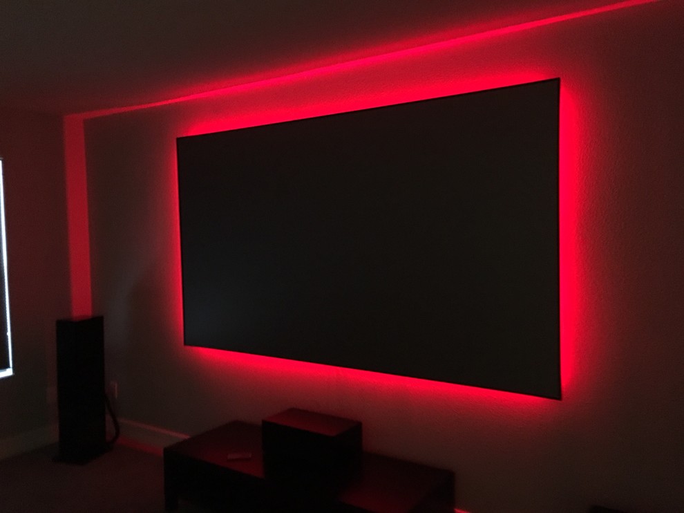 Example of a mid-sized urban open concept home theater design in Tampa with a projector screen