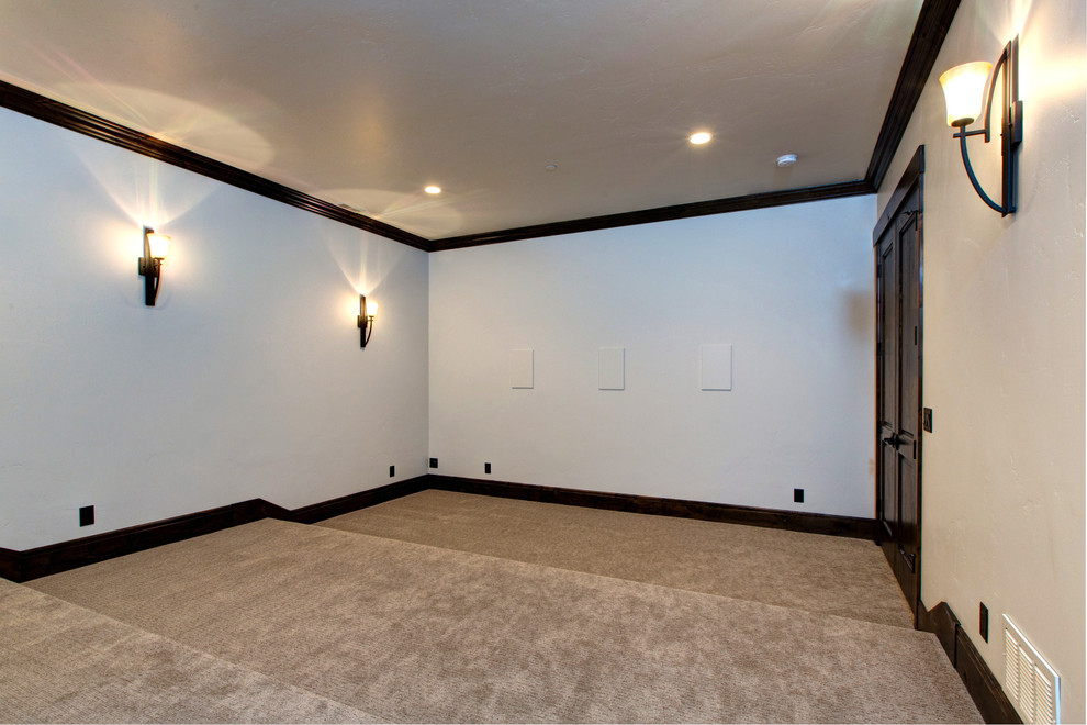 Example of a huge mountain style enclosed carpeted home theater design in Salt Lake City with white walls and a projector screen