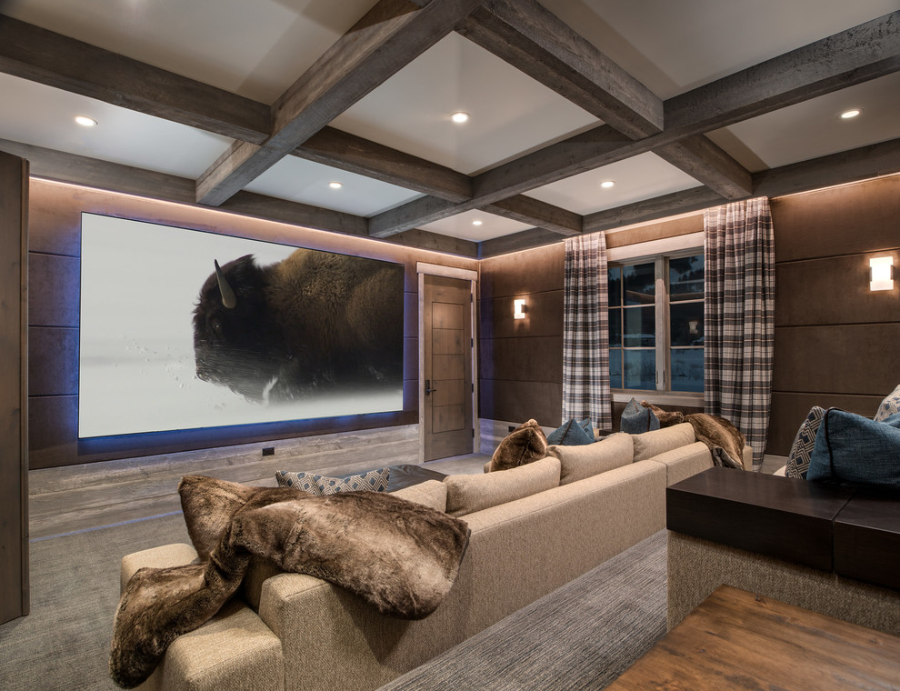 Cette image montre une salle de cinéma chalet avec un mur marron, moquette, un téléviseur fixé au mur et un sol gris.