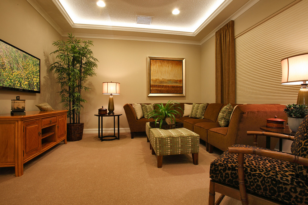 Home theater - tropical enclosed carpeted and beige floor home theater idea in Orlando with beige walls and a wall-mounted tv