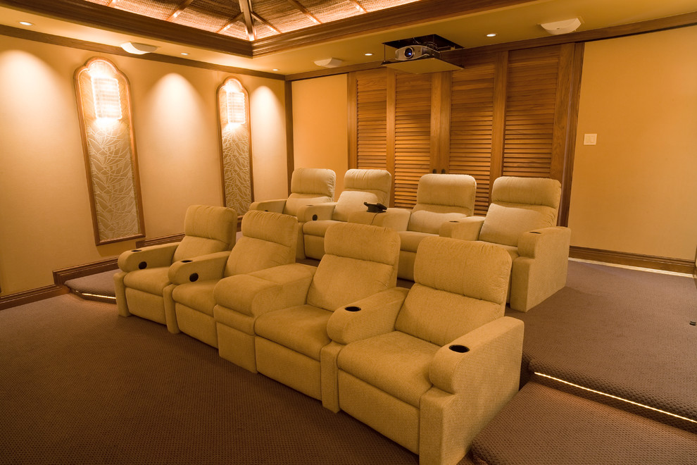 Aménagement d'une grande salle de cinéma bord de mer fermée avec un mur beige, moquette et un écran de projection.