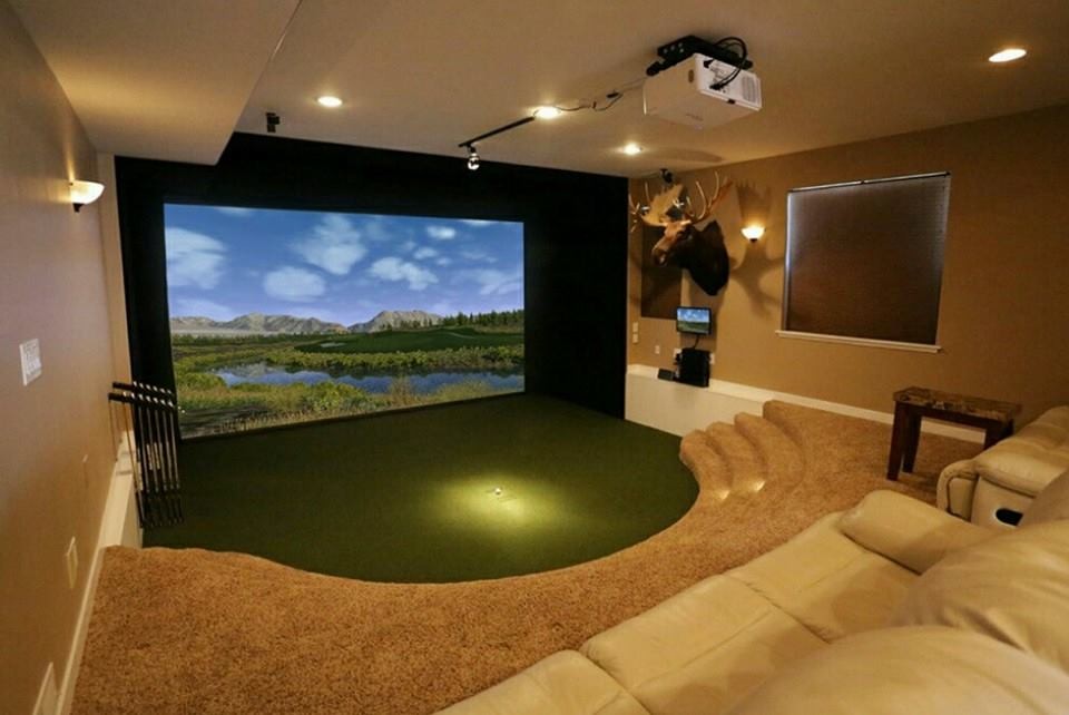 Modelo de cine en casa cerrado moderno pequeño con paredes beige, moqueta, pantalla de proyección y suelo beige